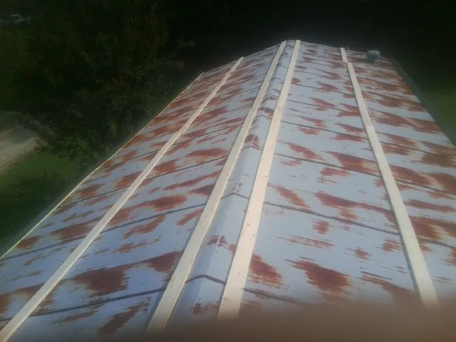 Rusted metal roof panels with new wood purlins before replacement — Storm Damage Roof Repair in Burnside by Roofing Brothers